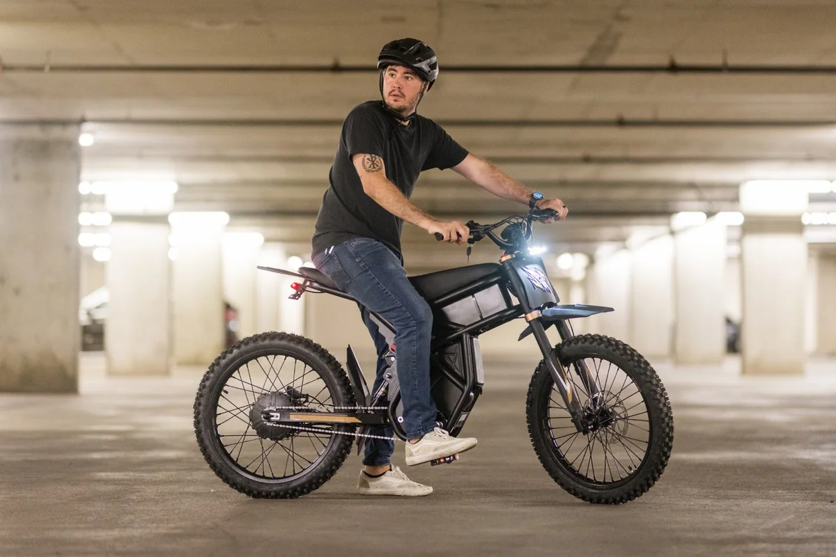 Rider on a black GT73 Pro electric motorbike in a parking garage