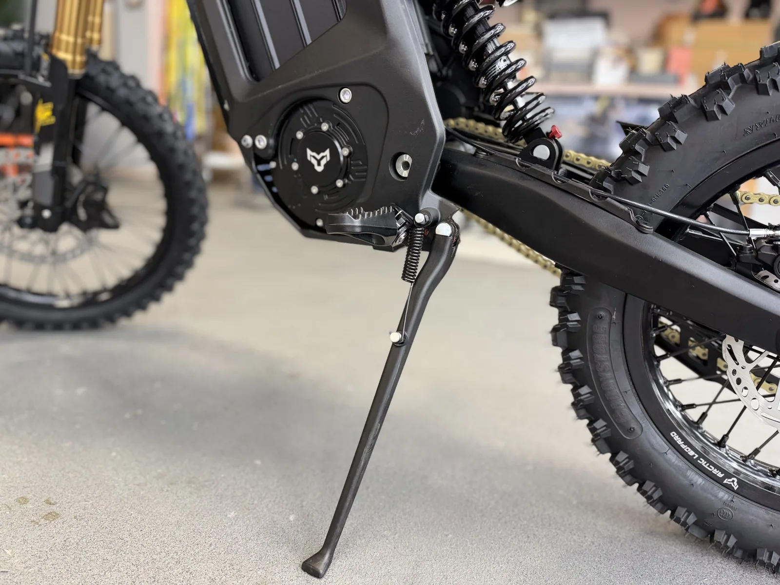 Arctic Leopard XF electric dirt bike rear wheel and kickstand detail