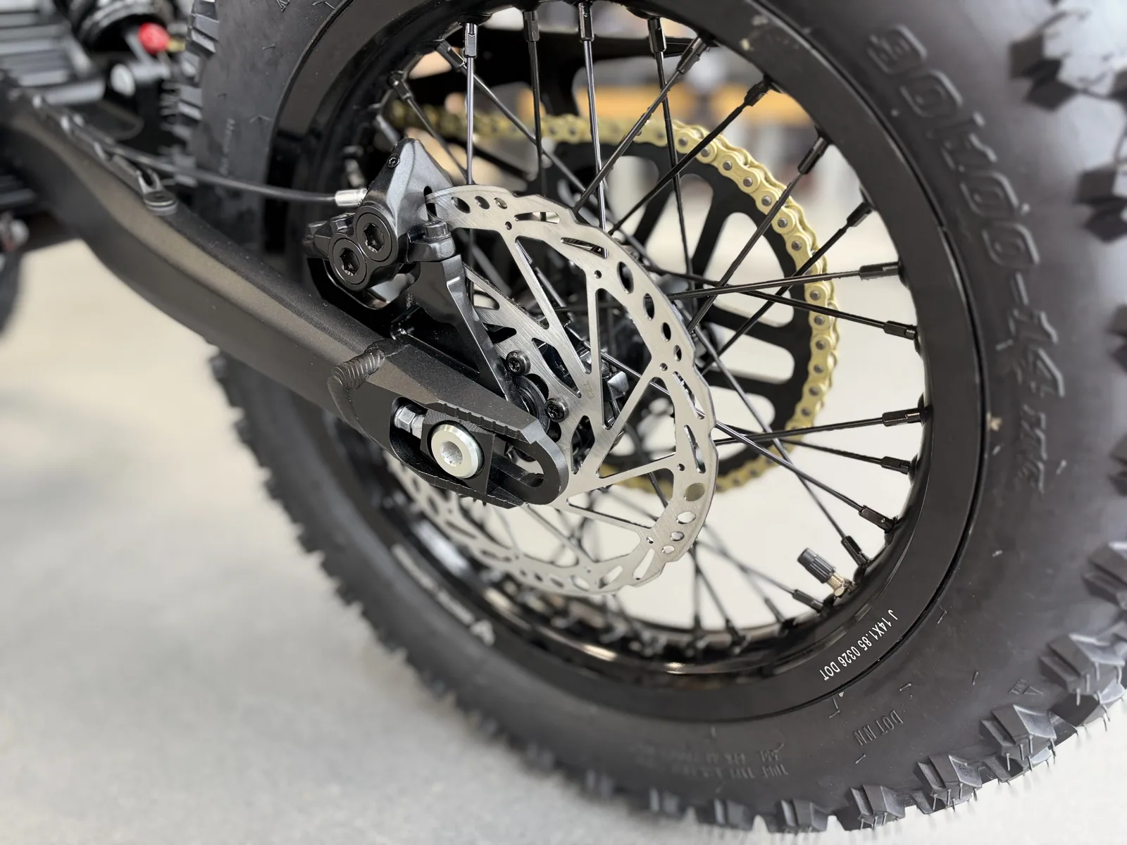 Arctic Leopard XF electric dirt bike rear brake disc and wheel detail