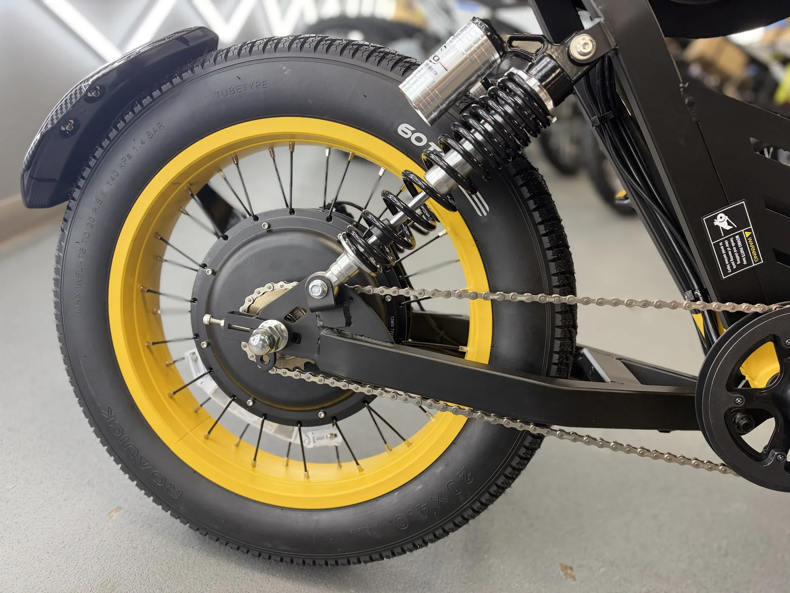 Yellow HappyRun G100 Pro electric dirt bike rear wheel and suspension detail