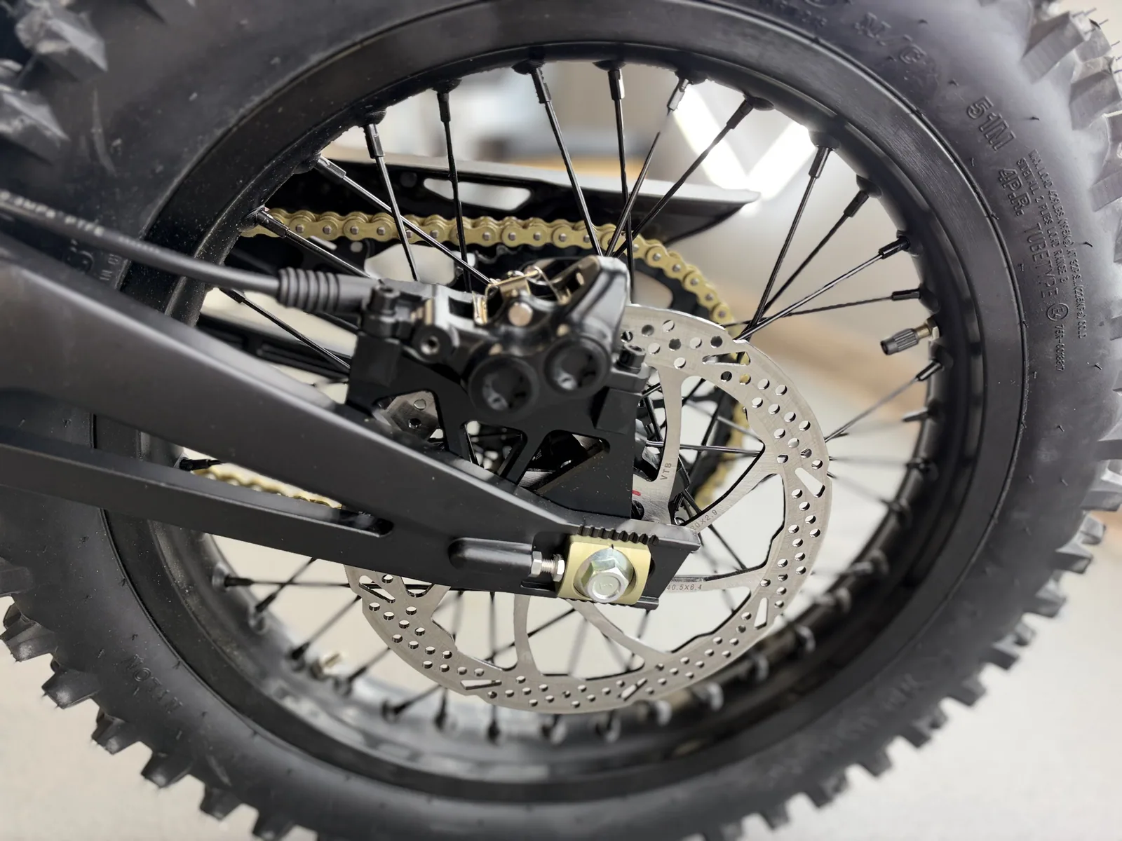Ventus V1+ EVO electric dirt bike rear wheel and brake caliper detail
